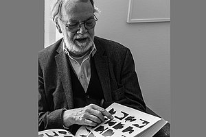 Wulf Herzogenrath im April 2025 mit dem Findbuch II der Kölner Künstlerin Monika Bartholomé (© Stefan Kraus)
