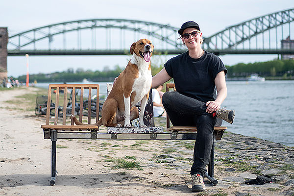 Erst kam der Hund, dann die Idee: Laura Kampf und Hund Smudo auf ihrer Bank am Rhein