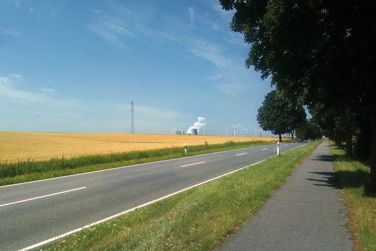 Foto: Christoph Ganslmeier / Stadtrevue Gute und böse Energie: Windräder bei Pulheim-Stommeln, im Hintergrund das RWE-Kraftwerk Neurath
