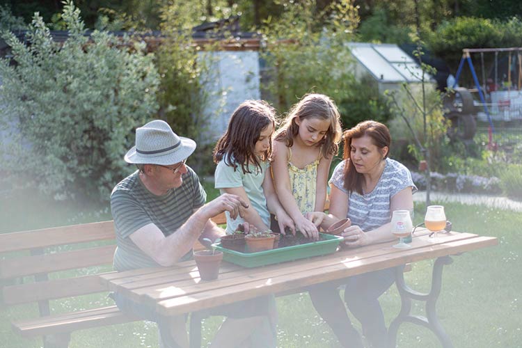 Foto: Jennifer Rumbach / Stadtrevue Reinhard und Miriam Schabbing topfen mit Tochter Eva (2. v. rechts) und deren Freundin Caja Setzlinge um